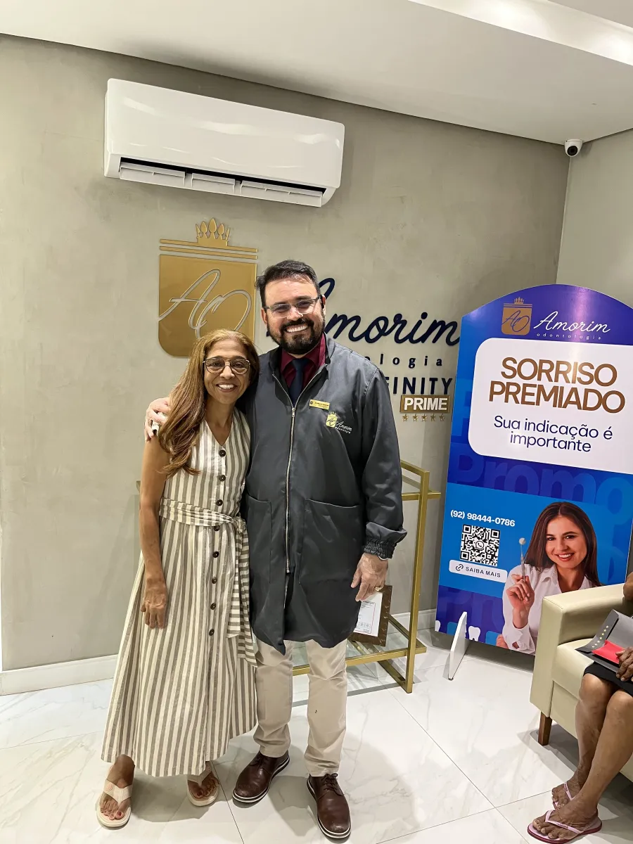 Dr. Marcio Amorim com paciente satisfeita na Amorim Odontologia
