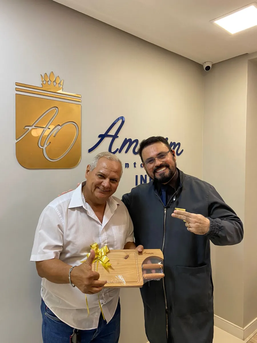 Dr. Marcio Amorim entregando lembrança a paciente da clínica